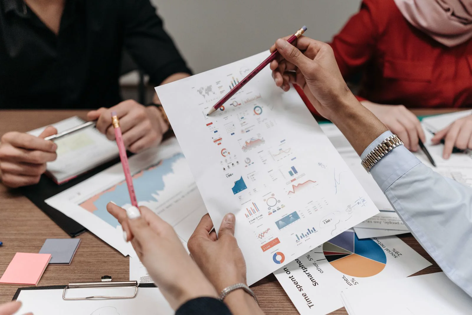 İş verilerini ve basılı grafikleri birlikte inceleyen bir ekip